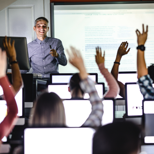 Teacher teaching in front of students in computer lab Teacher teaching in front of students in computer lab
